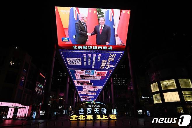 7일 (현지시간) 리창 중국 총리와 앤서니 앨버니지 호주 총리의 악수하는 모습이 베이징 쇼핑몰 밖의 거대한 영상으로 보이고 있다. 2023.11.8 ⓒ AFP=뉴스1 ⓒ News1 우동명 기자