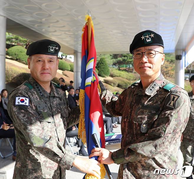 8일 육군 제1군단사령부에서 열린 57대 군단장 취임식에서 손식 지상작전사령관(왼쪽)이 주성운 신임 군단장에게 부대기를 전달하고 있다. (1군단 제공)