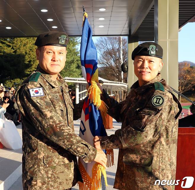 8일 오후 2군단 대연병장에서 실시된 제49·50대 2군단장 이·취임식 행사에서 새로 취임한 박후성 군단장(오른쪽)이 손식 지상작전사령관(왼쪽)으로부터 부대기를 이양받고 있다.(2군단 제공)