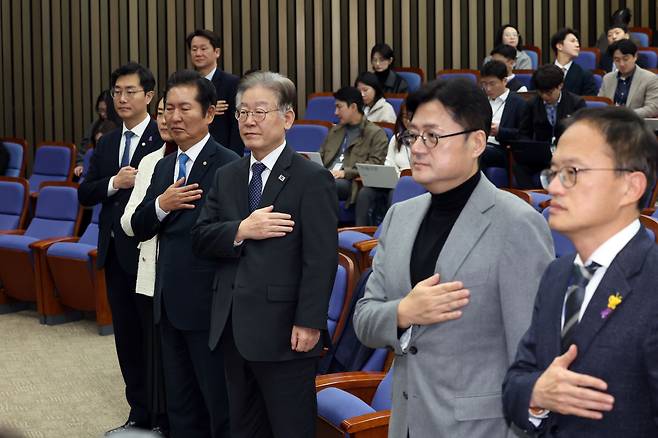 더불어민주당 이재명 대표와 홍익표 원내대표가 8일 오후 서울 여의도 국회에서 열린 의원총회에서 의원들과 국민의례를 하고 있다./뉴스1