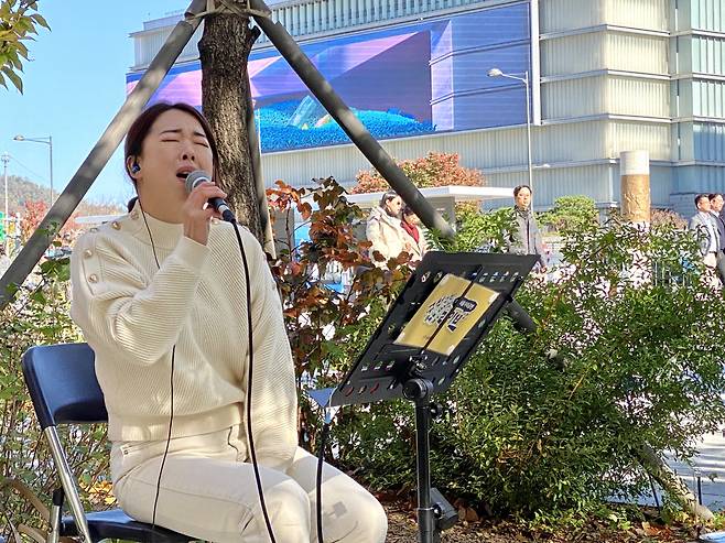 Ma Hak-jeong sings "Cheer Up" by C-Clef on the streets of the Gwanghwamun Square in Seoul on Tuesday. (Hwang Joo-young/The Korea Herald)