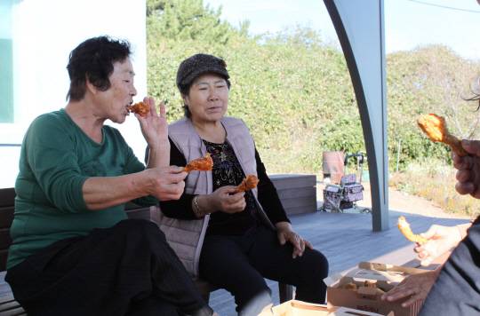 뭍에서 7㎞가량 떨어져 서해 가로림만 중간에 있는 충남 서산시 팔봉면 고파도에 배달음식과 생활용품 등을 드론으로 배송하는 실증 서비스가 지난달 13일부터 진행되고 있다. 사진은 지난 8일 오후 고파도 주민들이 드론으로 배송된 치킨을 맛있게 먹는 모습. [서산=연합뉴스]