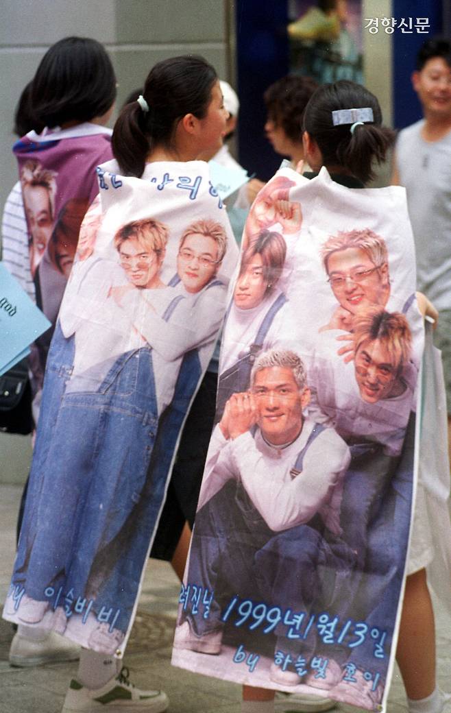god의 소녀팬들이 2001년 7월 20일 그룹 멤버 박준형의 생일을 축하하기 위해 멤버들의 얼굴이 새겨진 망토를 두르고 명동거리를 걷고 있다. / 서성일 기자