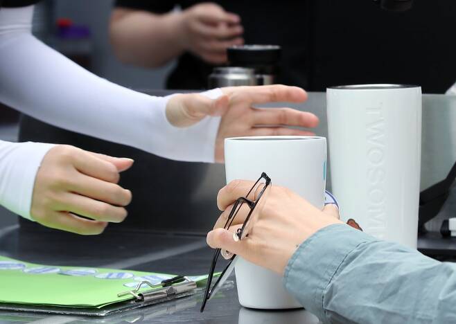 서울 중구 서울광장에서 열린 텀블러데이 행사에 텀블러(개인컵)를 가져온 시민들이 커피차에서 음료를 받고 있다. 뉴스1