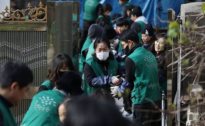 자원봉사자들이 연탄을 전달하며 밝은 표정을 보이고 있다. /박성원 기자