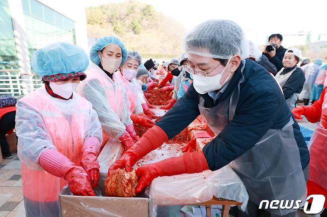 이상일 시장(오른쪽)이 14일 시청 광장에서 열린 '사랑나눔 김장축제'에서 봉사자들과 김장을 하고 있다.(용인시 제공)