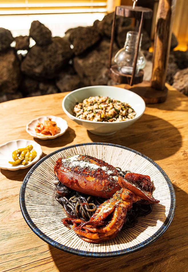 통오징어를 올려주는 선재도 식당 '다딤길목'의 '먹물 오징어 파스타'. 현무암으로 밭담처럼 꾸민 실내 공간은 제주도의 어느 식당 같다. / 이경호 영상미디어 기자