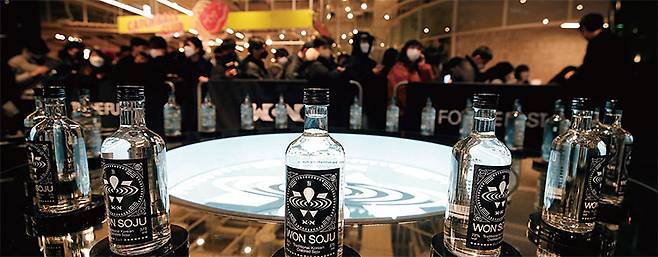 작년 2월 서울 영등포구 더현대서울에서 프리미엄 증류식 소주 브랜드 원소주 팝업 스토어 오픈 행사 참가 시민들이 원소주를 사기 위해 길게 줄을 서 있다. 사진 뉴스1