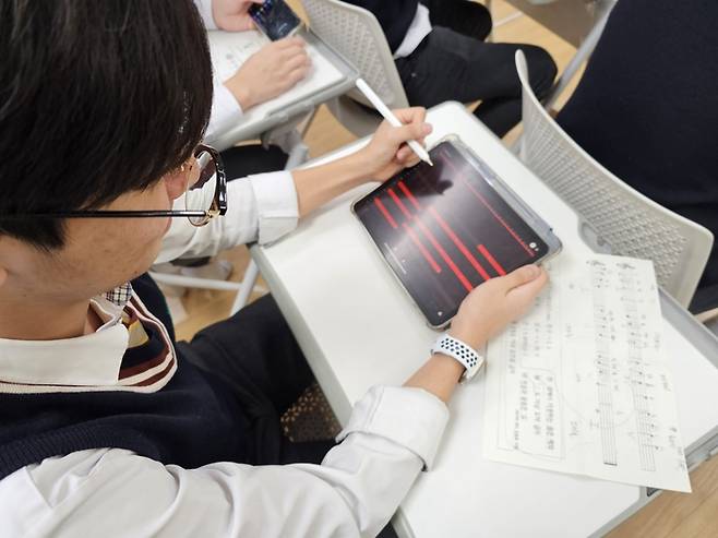 대제중학교 학생이 태블릿에서 어플리케이션을 활용해 음악을 창작해 보는 활동을 하고 있다.