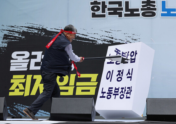 김동명 한국노총 위원장이 6월27일 오후 서울 중구 남대문 인근에서 열린 ‘윤석열정권 심판! 최저임금 인상! 한국노총 노조간부 결의대회’에서 이정식 노동부 장관 이름이 적힌 조형물을 부수는 행위극을 하고 있다. 신소영 기자 viator@hani.co.kr