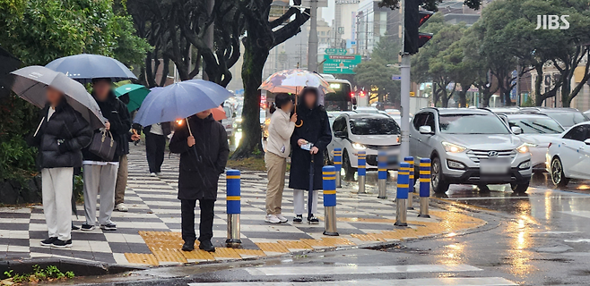 오늘(16일) 오후 수능을 마친 제주지구 제1시험장인 제주 남녕고등학교 인근 건널목. 한 학부모가 시험을 치른 수험생 자녀와 함께 신호를 기다리고 있는 모습(사진, 신동원 기자)