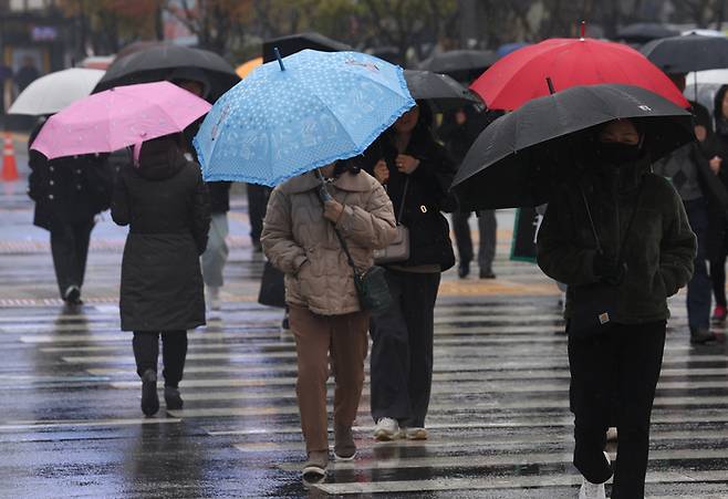 16일 오전 서울 광화문광장 인근에서 갑자기 비가 내리자 시민들이 우산을 쓰고 이동하고 있다.연합뉴스