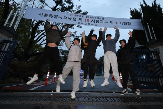 Students jump in excitement after completing the College Scholastic Ability Test (CSAT) at a high school in Jongno District, central Seoul, on Thursday. [NEWS1]