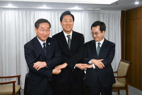 From left, Incheon Mayor Yoo Jeong-bok, Seoul Mayor Oh Se-hoon and Gyeonggi Governor Kim Dong-yeon pose before a meeting to discuss the proposed merger of Gimpo, Gyeonggi, into Seoul at Korea Press Center in Jung District, Seoul on Thursday. The annexation of Gimpo was proposed by the People Power Party (PPP), to which both the Incheon and Seoul mayors are members, while the Gyeonggi governor is a member of the Democratic Party. However, the Incheon mayor has criticized his party’s decision to bring Gimpo into Seoul. The PPP on Thursday submitted a bill to the National Assembly detailing the merging of Gimpo into Seoul. [JOINT PRESS CORPS]