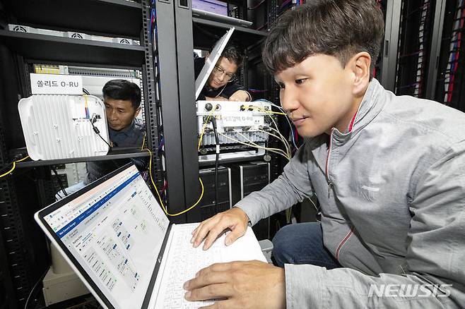 [서울=뉴시스]KT가 국내외 장비 제조사와 함께 5G 상용 기지국에 서로 다른 제조사의 오픈랜 무선장비(O-RU)를 연동하는 데 성공했다고 16일 밝혔다. KT와 쏠리드, 에프알텍 관계자가 5G 상용 기지국과 멀티 벤더의 O-RU 연동을 테스트하는 모습. (사진=KT 제공)