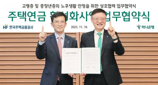 16일 서울 중구 하나은행 본점에서 이승열 하나은행장(오른쪽)이 최준우 한국주택금융공사 사장과 주택연금 활성화사업을 위한 업무협약을 체결 후 기념촬영을 하고 있다.(사진제공=하나은행)