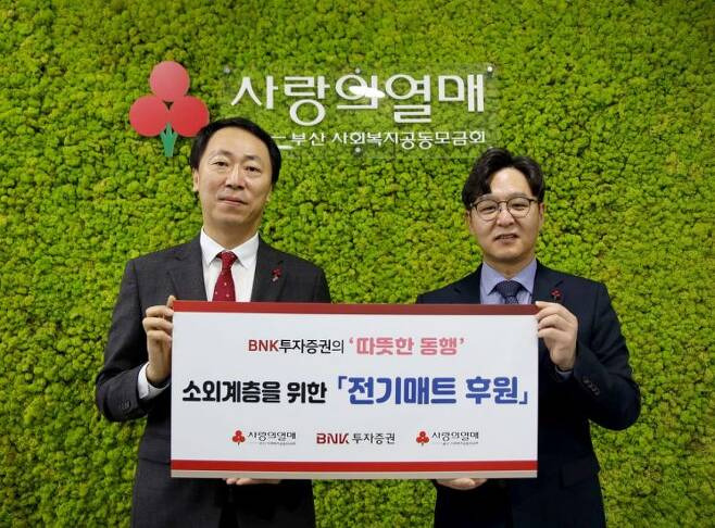 BNK투자증권 이영걸 시너지추진부장(왼쪽)과 부산사회복지공동모금회 박선욱 사무처장이 전기매트 후원 기념사진을 찍고 있다./사진=BNK투자증권 제공