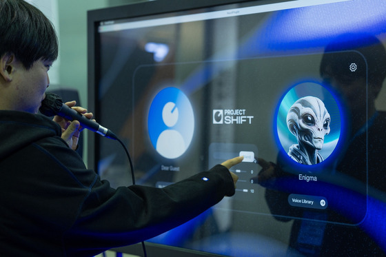 A visitor tries out Project Shift, a technology which can convert his voice to a game character's voice in real time at Bexco, Busan, on Friday. [HYBE]