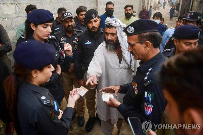 신분증 확인하는 파키스탄 경찰 (카라치 AFP=연합뉴스) 17일(현지시간) 파키스탄 카라치에서 경찰이 불법 이민자를 단속하기 위해 시민들의 신분증을 확인하고 있다. 2023.11.18. photo@yna.co.kr