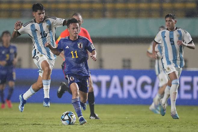 <YONHAP PHOTO-4057> Japan's Rento Takaoka, center, goes past Argentina's Thiago Laplace during their FIFA U-17 World Cup Group D soccer match at Si Jalak Harupat Stadium in Bandung, West Java, Indonesia, Tuesday, Nov. 14, 2023. (AP Photo/Achmad Ibrahim)/2023-11-14 23:07:30/ <저작권자 ⓒ 1980-2023 ㈜연합뉴스. 무단 전재 재배포 금지.>