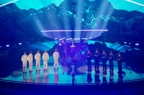 Chinese team Weibo Gaming, left, and Korea's T1 stand on stage during the opening ceremony before the first match of the best-of-five final round at Gocheok Sky Dome in western Seoul on Sunday. [JOINT PRESS CORPS]