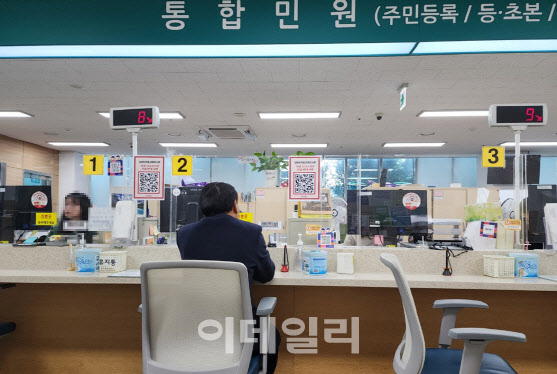 20일 오전 9시께 서울 마포구 서교통 합정동 주민센터에서 민원인이 창구 의자에 앉아 서류 발급을 기다리고 있다.(사진=황병서 기자)