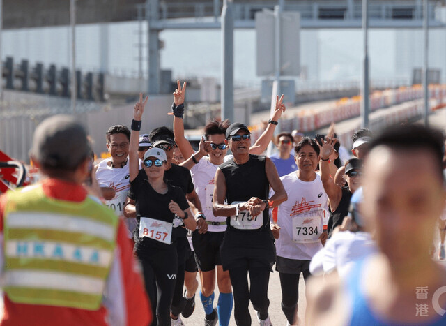지난 19일(현지시각) 홍콩에서 열린 제1회 홍콩 주하이-마카오 대교 하프 마라톤 대회에 참가한 배우 저우룬파(주윤발·가운데)가 다른 참가자들에 둘러싸여 달리고 있는 모습. 소후닷컴 누리집 갈무리