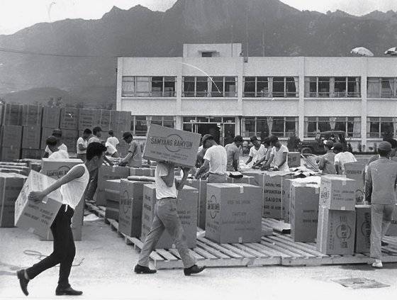 1969년 삼양식품 직원들이 국내 최초로 수출되는 삼양라면을 옮기고 있다. 사진 삼양식품