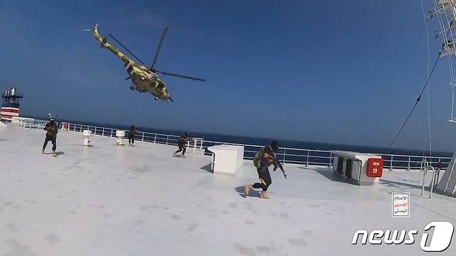 20일(현지시간) 공개된 사진에서 예멘 후티 반군의 헬리콥터가 홍해 지역에서 화물선인 갤럭시 리더호 위를 지나고 있으며 갑판에는 무장 대원들이 올라타 걸어가고 있다. 2023.11.21 ⓒ 로이터=뉴스1 ⓒ News1 정지윤 기자