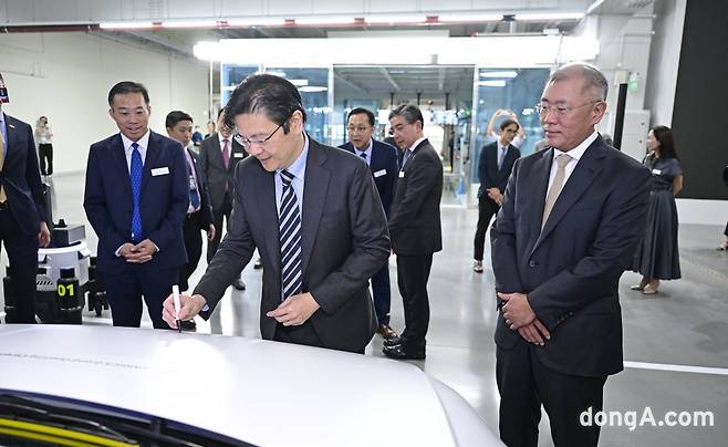 로렌스 웡 싱가포르 부총리가 아이오닉 5 자율주행 로보택시에 기념 서명하고 있다.