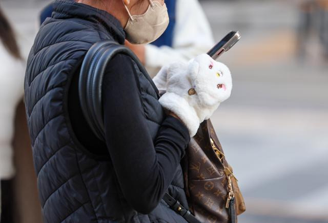 내륙 아침 기온이 영하권까지 떨어지며 추운 날씨를 보인 20일 오전 서울 청계광장에서 한 관광객이 털장갑을 끼고 스마트폰을 하고 있다. 기상청에 따르면 23일까지는 일교차는 커도 낮에는 포근한 날씨가 이어지다가, 24일 아침부터 기온이 확 떨어지면서 주말까지 추운 날씨가 계속되겠다. 연합뉴스