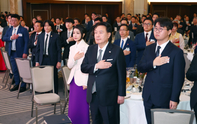 ▲ 영국을 국빈 방문한 윤석열 대통령과 부인 김건희 여사가 20일(현지시간) 런던의 한 호텔에서 열린 동포 만찬 간담회에서 국기에 경례하고 있다. 연합뉴스