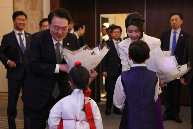 영국을 국빈 방문 중인 윤석열 대통령과 부인 김건희 여사가 20일(현지 시간) 런던의 한 호텔에서 열린 동포 만찬 간담회에서 화동으로부터 꽃다발을 받고 있다. 런던=연합뉴스