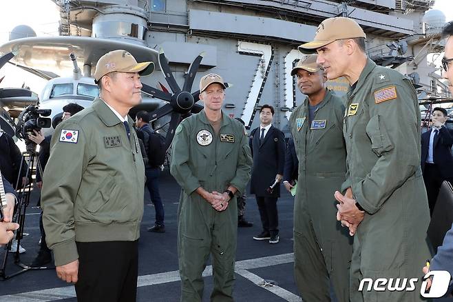 신원식 국방부 장관이 22일 부산 남구 해군작전사령부 부산작전기지에 입항한 미 해군 니미츠급 핵추진 항공모함 CVN-70 칼빈슨함을 찾은 미1항모강습단장 카를로스 사르디엘로 준장으로부터 설명을 듣고 있다. (국방부 제공) 2023.11.22/뉴스1