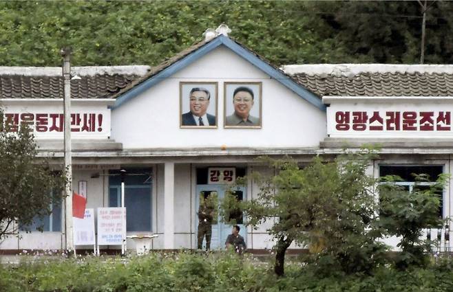 중국 길림성에서 바라본 북한 함경북도 역에 김일성·김정일 초상화가 걸려 있다./연합뉴스