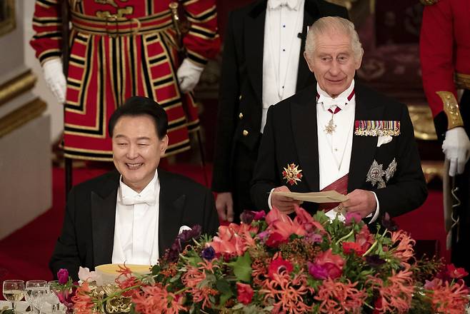 President of South Korea Yoon Suk Yeol (left) listens as King Charles III speaks at the state banquet at Buckingham Palace, London, Tuesday. (Pool photo via AP-Yonhap)