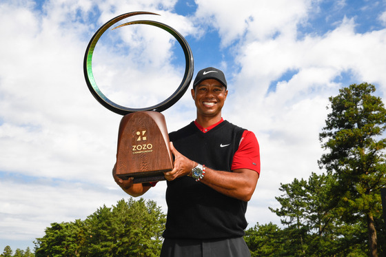 Tiger Woods holds the tournament trophy on the 18th green after the final round of The Zozo Championship at Accordia Golf Narashino Country Club on Oct. 28, 2019 in Chiba, Japan. [GETTY IMAGES]