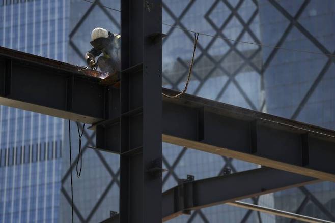 A worker welds on a construction building in Beijing, Monday, Aug. 22, 2022. Asian stock markets were mixed Monday after China cut an interest rate that affects mortgage lending while investors looked ahead to this week's Federal Reserve conference for signals about more possible U.S. rate hikes to cool surging inflation. (AP Photo/Andy Wong) /사진=ap 뉴시스