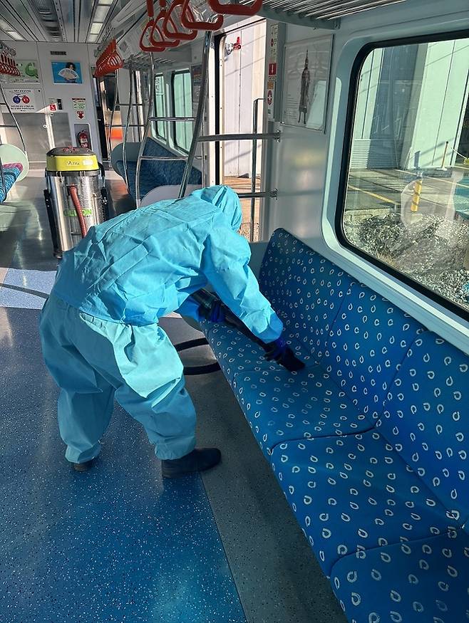 전문방역 요원이 부산도시철도 전동차 객실 좌석을 진공흡착청소기로 청소하고 있다. 부산교통공사 제공