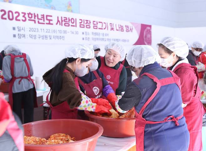 덕성여대는 22일 학생회관 로비에서 ‘2023 사랑의 김장 담그기·나눔 봉사활동’을 진행했다. 김건희 총장(가은데)이 봉사자들 속에서 함께 김장을 담그며 격려하고 있다.(사진=덕성여대)