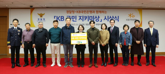 23일 서울 서대문구 소재 경찰청에서 열린 'KB 국민 지키미상' 시상식에서 김봉식 경찰청 수사국장(왼쪽 첫번째), 박영세 KB국민은행 소비자보호그룹 대표(왼쪽 열두번째)가 수상자들과 기념촬영을 하고 있다. 국민은행 제공.