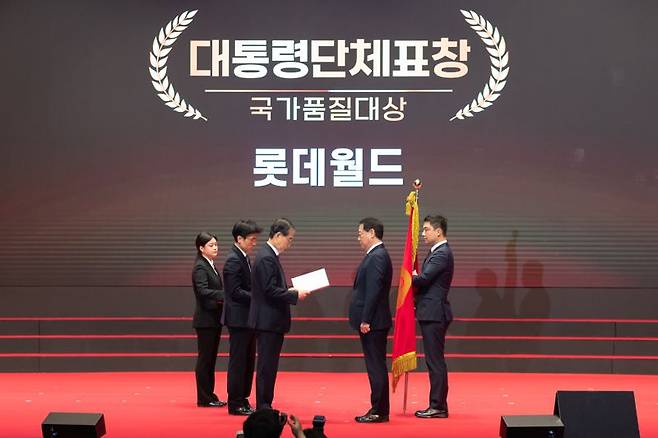 최홍훈 롯데월드 대표(앞줄 오른쪽)가 22일 열린 제49회 국가품질경영대회에서 한덕수 국무총리(앞줄 왼쪽)로부터 국가품질대상 대통령 표창을 받고 있다. 롯데월드 제공