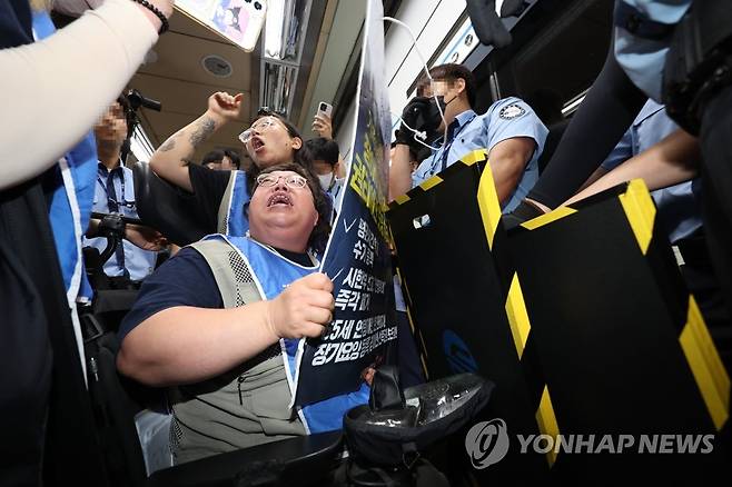 서울교통공사 직원들과 대치하는 전장연 (서울=연합뉴스) 박동주 기자 = 29일 오전 서울 삼각지역에서 전장연 관계자들이 장애인 권리예산 보장 등을 촉구하며 지하철 '연착투쟁' 행동계획 발표 기자회견을 마치고 지하철을 타려다가 탑승 시 팻말 소지 가능 여부 등을 놓고 서울교통공사 직원들과 대치하고 있다. 2023.6.29 pdj6635@yna.co.kr