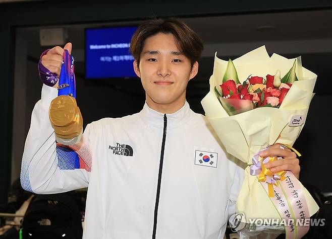 김우민, '저 3관왕이에요' (영종도=연합뉴스) 한종찬 기자 = ' '2022 항저우 아시안게임'에서 3관왕을 차지한 수영 국가대표 김우민이 30일 오후 인천국제공항 제1여객터미널을 통해 귀국한 뒤 메달을 들어보이고 있다. 2023.9.30 saba@yna.co.kr