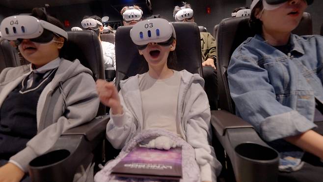 People experience aespa's virtual reality concert, "Lynk-Pop: The 1st VR Concert," at Coex's Megabox in southern Seoul on Oct. 25. (AmazeVR, SM Entertainment, Studio Realive)