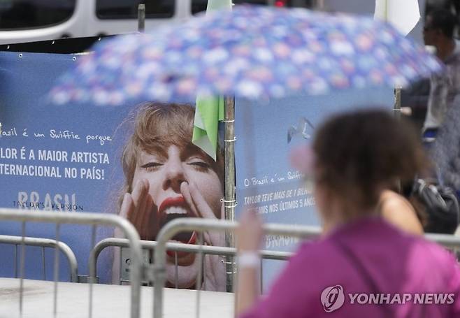 Taylor Swift fan waits for the doors of Nilton Santos Olympic stadium to open for her Eras Tour concert amid a heat wave in Rio de Janeiro, Brazil, Saturday, Nov. 18, 2023. A 23-year-old Taylor Swift fan died at the singer's Eras Tour concert in Rio de Janeiro Friday night, according to a statement from the show's organizers in Brazil. (AP Photo/Silvia Izquierdo)