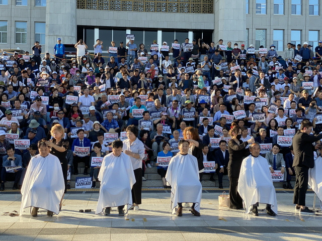 ▲새만금SOC예산 삭감에 항의하며 전북 국회의원들이 국회의사당 앞에서 머리를 깎고 있다 ⓒ전북도