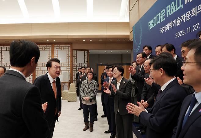 윤석열 대통령이 27일 서울 용산 대통령실 청사에서 열린 국가과학기술자문회의 민간위원 오찬 간담회에서 참석자들과 기념촬영을 마친 뒤 대화하고 있다. (사진=대통령실)