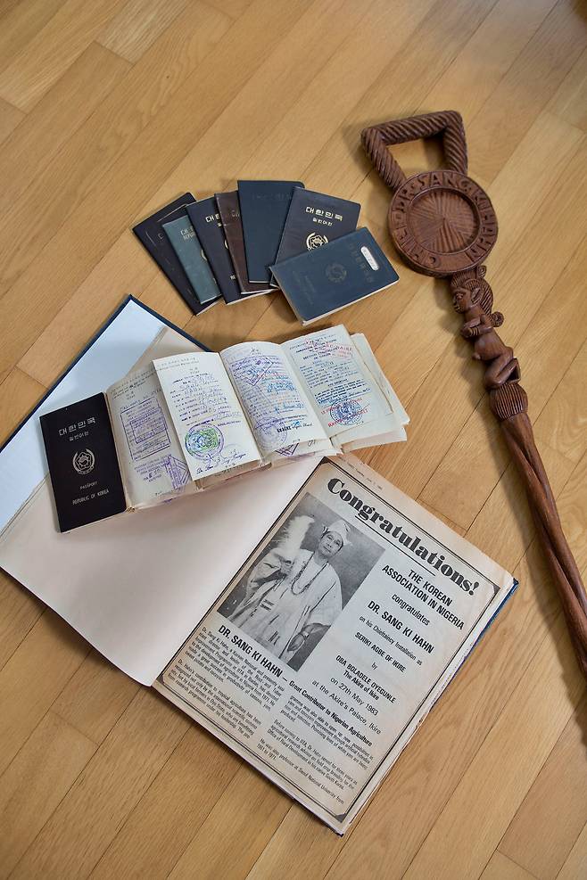 한상기 박사가 추장으로 추대된다는 뉴스가 실린 나이지리아 현지 신문과 추장 지팡이, 그동안 사용한 여권 무더기. 국제열대농학연구소(IITA)에서 23년 근무하는 동안 한 박사는 여권에 도장 찍을 자리가 부족해 종이를 여러 장 덧대 사용해야 할 정도로 출장이 잦았다. /한준호 영상미디어 기자