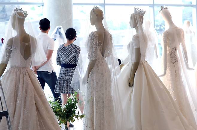 지난 2019년 서울에서 열린 한 웨딩박람회에서 예비 부부가 드레스 등 결혼 관련 상품을 둘러보고 있다./뉴스1